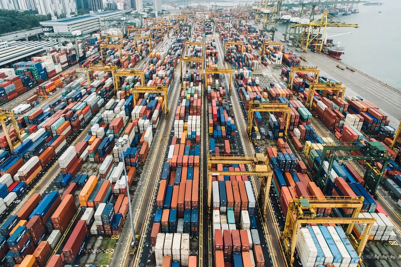 A large container port with rows of colourful containers and cranes